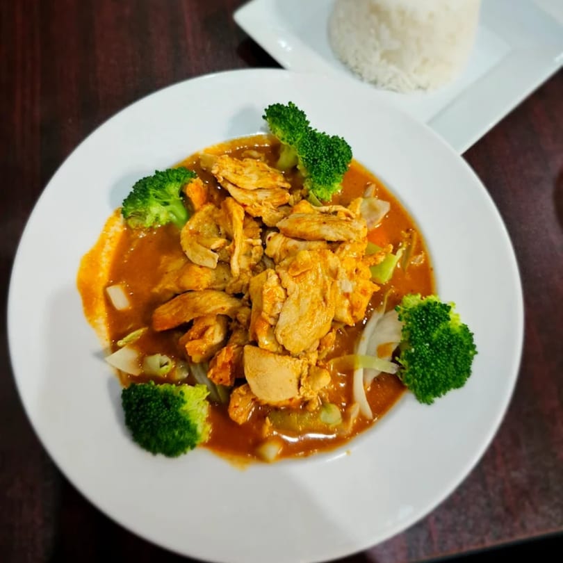 Thai Pattaya's chicken curry with broccoli and onions, served with a side of white rice.
