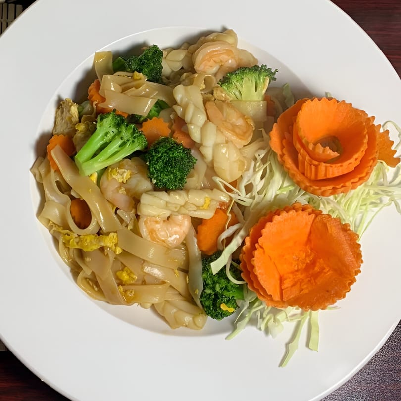 Thai Pattaya Restaurant's Pad See Ew with shrimp, squid, broccoli, carrots, and decorative carved carrots.
